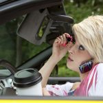 Woman putting on makeup while driving Woman putting on makeup while driving