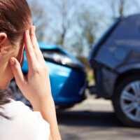 stressed driver sitting on roadside after car accident