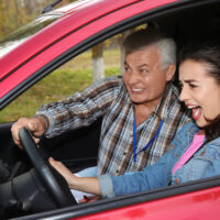 Young woman and senior instructor in car. Fail driving license exam