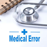 Stethoscope on notebook and pencil with Medical Error words as medical concept. Stethoscope on notebook and pencil with Medical Error words as medical concept.