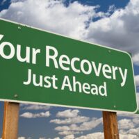 Your Recovery Green Road Sign Over Dramatic Clouds and Sky. Your Recovery Green Road Sign Over Dramatic Clouds and Sky.