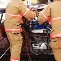 Firemen try to cut a car