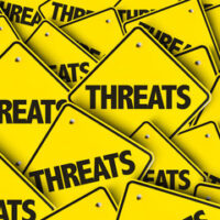 Yellow sign reads threats