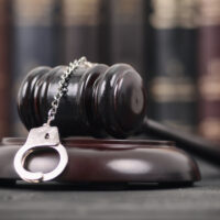 Judge Gavel and Handcuffs on a black wooden background. Judge Gavel and Handcuffs on a black wooden background.