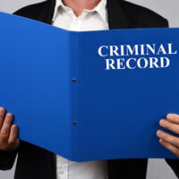 criminal record blue file being read by businesswoman criminal record blue file being read by businesswoman