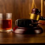 Whiskey with car keys and handcuffs. Concept for drinking and driving Whiskey with car keys and handcuffs. Concept for drinking and driving