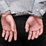 business man arrested with handcuffs on his back business man arrested with handcuffs on his back