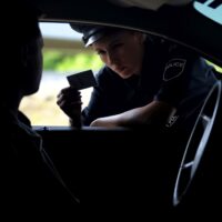 Police woman checking documents of driver, inspection on road, t Police woman checking documents of driver, inspection on road, t