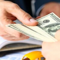 Client arm give pack of hundred dollars bills Client arm give pack of hundred dollars bills