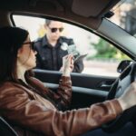 Male cop in uniform writes a fine to female driver Male cop in uniform writes a fine to female driver