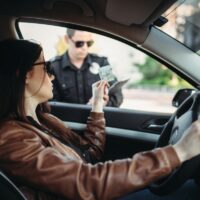 Male cop in uniform writes a fine to female driver