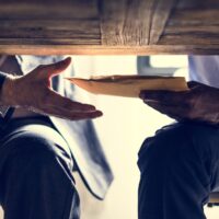 Business people sending documents under the table