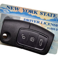 New York State driver license and car key isolated on white background. New York State driver license and car key isolated on white background.
