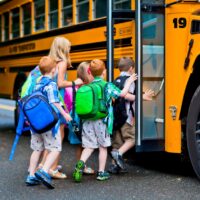 A group of young children getting on the schoolbus