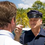 Police officer holding a pen and doing a field sobriety test on a motorist. Police officer holding a pen and doing a field sobriety test on a motorist.