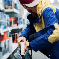 close up consumer thief’s hands putting the new gadget in the pocket in the store