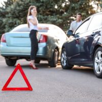 Emergency stop sign near broken cars after accident on road