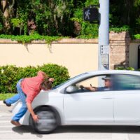 A man that is texting while driving runs over a pedestrian.