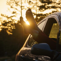 Two feet of the ground, young woman in the car barefooted driving barefoot