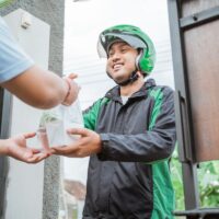 man ordering food online man ordering food online and receive the order at home delivered by courier