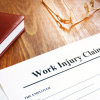 Work injury claim form and glasses on desk.