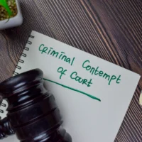 criminal-contempt-of-court-write-on-a-book-isolated-on-wooden-table