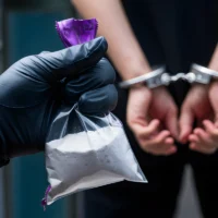 hand-holding-bag-of-white-powder-with-purple-zipper